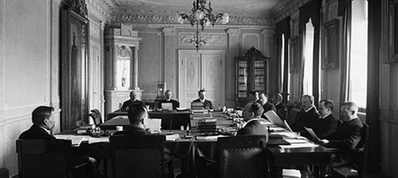 Tokoisenatens ekonomiavdelnings plenum. Från vänster runt bordet: Kyösti Kallio, Matti Paasivuori, Rudolf Holsti, Julius Ailio, Leo Ehrnrooth, Emil Setälä, Oskari Tokoi, Allan Serlachius, Väinö Voionmaa, Antti Tulenheimo, Väinö Tanner och Väinö Vuolijoki.