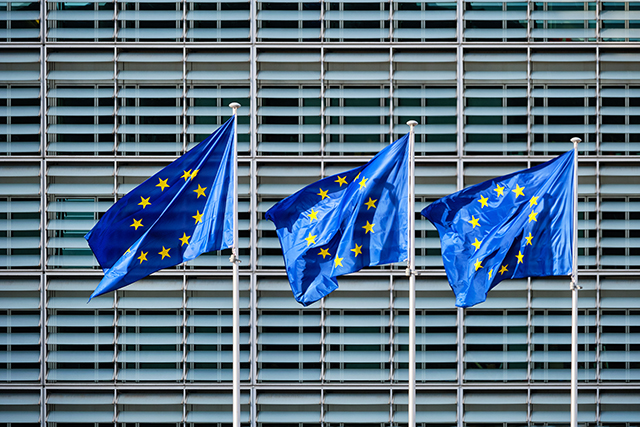 Kolme EU:n lippua rakennuksen seinän edustalla