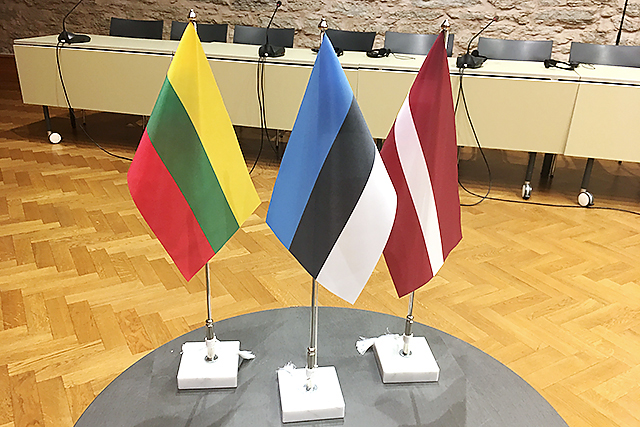 Liettuan, Viron ja Latvian liput vierekkäin kokoushuoneen pöydällä.